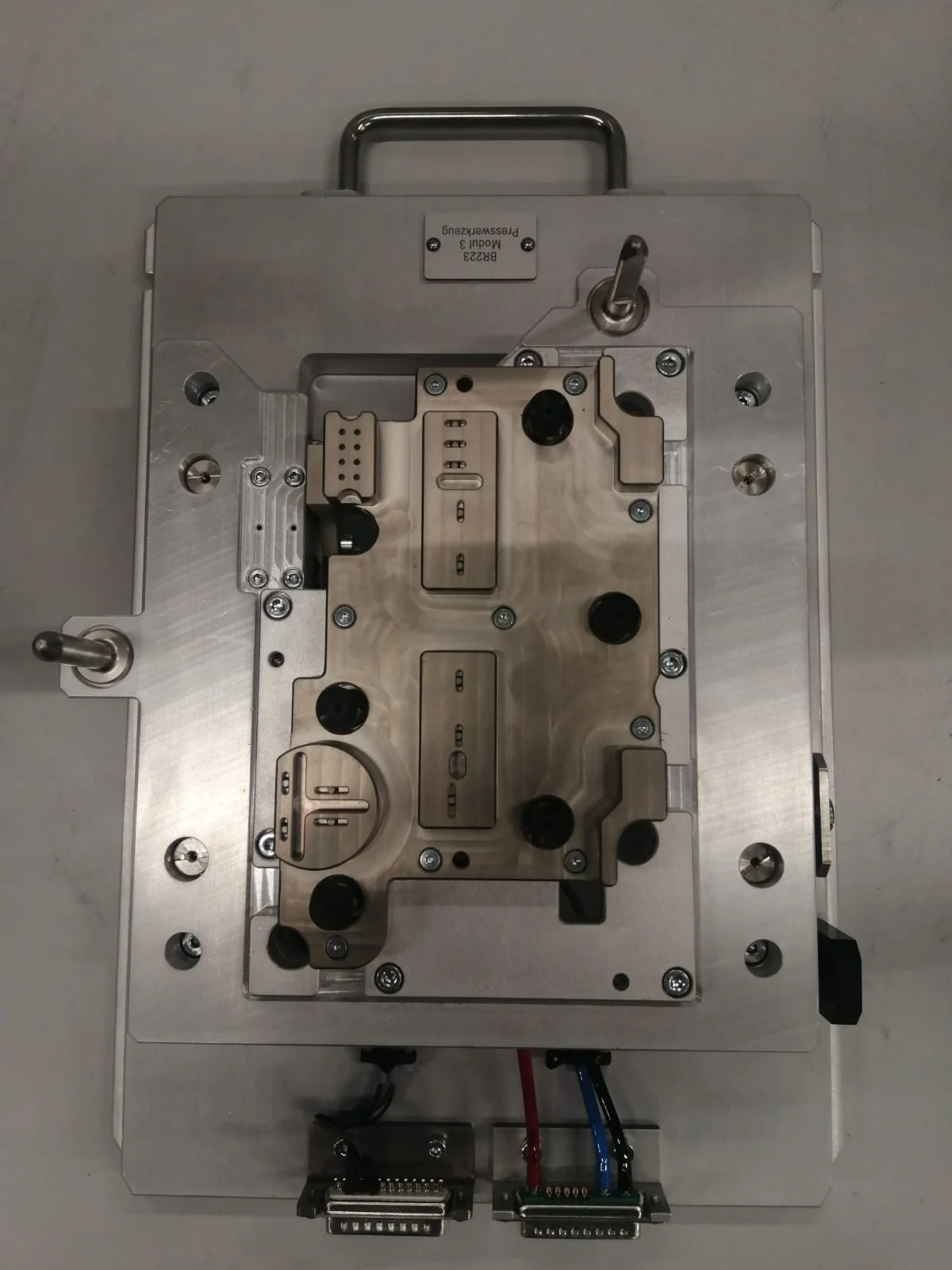 Populated carrier plate with contact pins and carrying handles